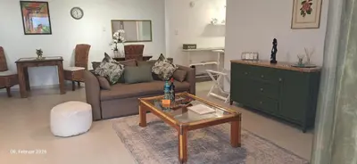 a living room with a couch and a table at Agape Apartments in Somerset West