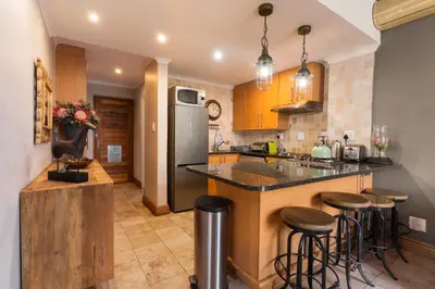 a kitchen with a island with bar stools at Avemore Eikehoff No 23 - full Backup Power in Stellenbosch