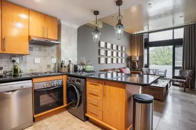 a kitchen with wooden cabinets and a dishwasher at Avemore Eikehoff No 23 - full Backup Power in Stellenbosch