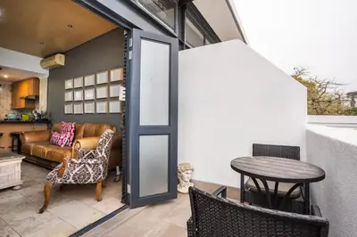 a living room with a table and chairs and a kitchen at Avemore Eikehoff No 23 - full Backup Power in Stellenbosch