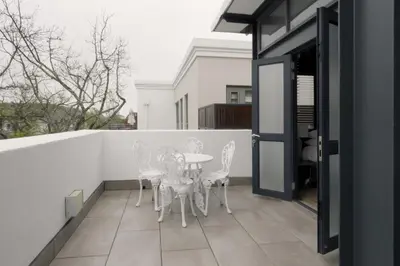 a patio with a table and chairs on a balcony at Avemore Eikehoff No 23 - full Backup Power in Stellenbosch