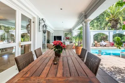 a dining room with a wooden table and chairs at Maison du Cap in Cape Town