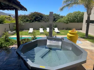 a swimming pool with a table in a backyard at Bird's View Guest Accommodation in Hermanus
