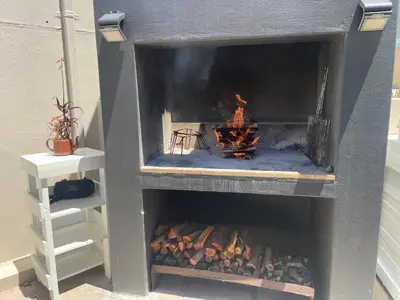 a fireplace with a fire inside of it at Bird's View Guest Accommodation in Hermanus