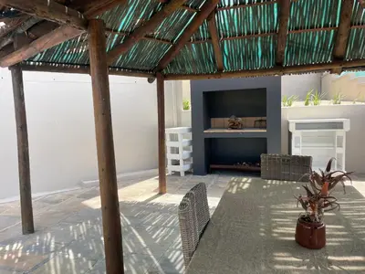 a living room with a table and chairs and a television at Bird's View Guest Accommodation in Hermanus