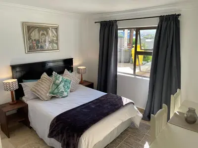 a bedroom with a large bed and a window at Bird's View Guest Accommodation in Hermanus