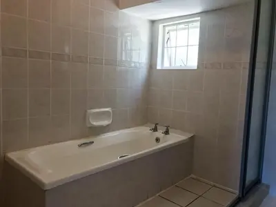 a bathroom with a bath tub and a window at Howards End Manor B&B in Cape Town