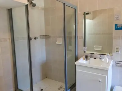 a bathroom with a shower and a sink at Howards End Manor B&B in Cape Town