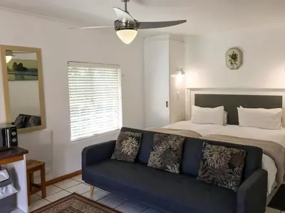 a living room with a bed and a couch at Howards End Manor B&B in Cape Town