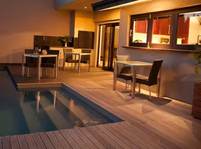 a swimming pool with tables and chairs and a kitchen at Keren's Vine Guesthouse in Stellenbosch