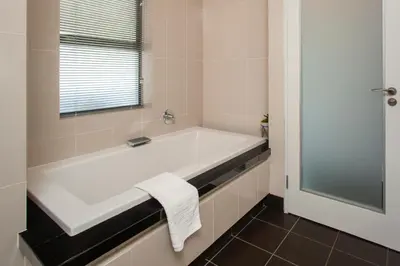 a white bath tub in a bathroom with a window at Hamewith Penthouse in Hermanus