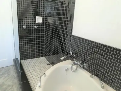 a bathroom with a shower with a tub and a sink at Eastbury Cottage in Hermanus