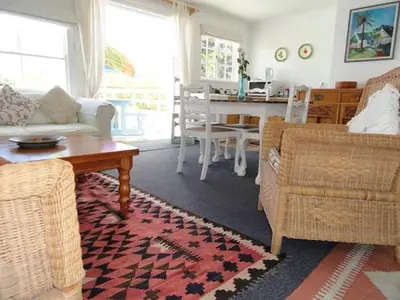 a living room with a couch and chairs and a table at Eastbury Cottage in Hermanus