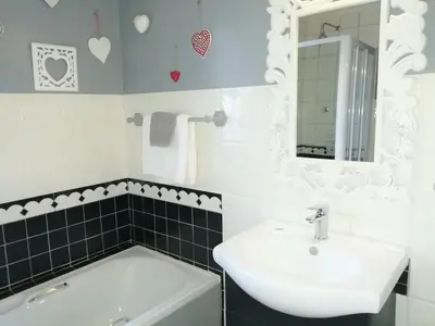 a white bathroom with a sink and a mirror at Eastbury Cottage in Hermanus