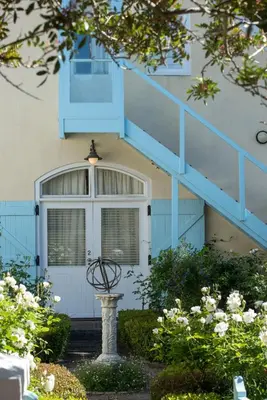 a house with a blue staircase and a window at Auberge Clermont in Franschhoek