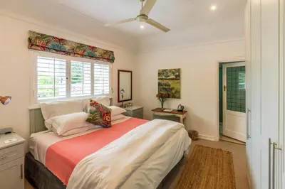 a bedroom with a large bed and a window at Hedge House Guest House in Cape Town