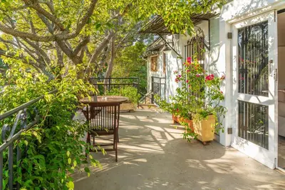 a patio with a table and chairs on a house at Hedge House Guest House in Cape Town