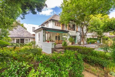 an exterior view of a house with trees at Hedge House Guest House in Cape Town