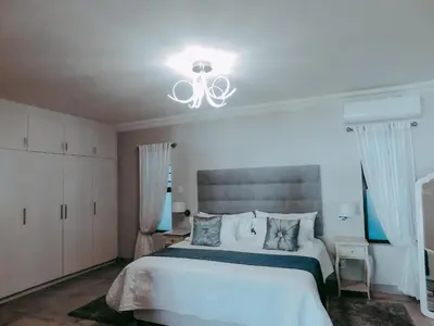 a bedroom with a white bed and a white ceiling at Arcangeli Wines in Botrivier