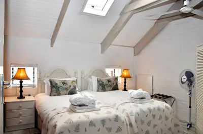 a bedroom with two beds with towels on them at Los Olivos at the Yard in Franschhoek