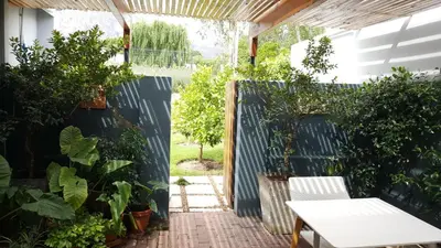 a patio with plants and a white table at 5 Pierre Jourdan in Franschhoek