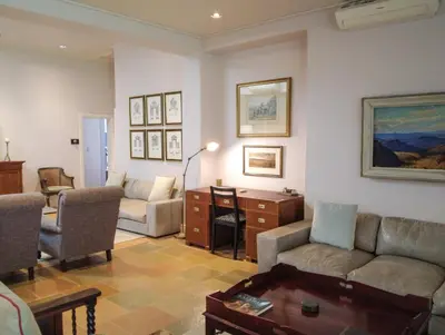 a living room with a couch and a table at Laanhof Victorian House Self-Catering in Stellenbosch