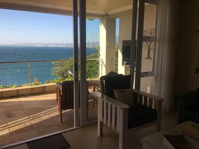 a living room with a view of the ocean at The Blue Marine Self-Catering in Gordonʼs Bay