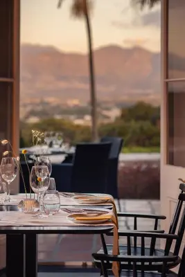a table with wine glasses sitting on top of it at Grande Roche Hotel in Paarl