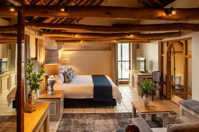 a bedroom with a bed and a living room at Grande Roche Hotel in Paarl