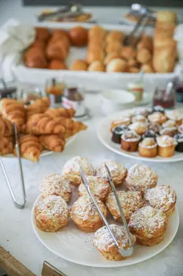 a table topped with plates of donuts and other pastries at Grande Roche Hotel in Paarl
