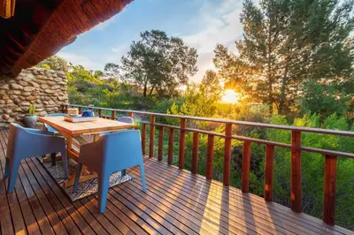 a wooden deck with a table and chairs on it at Tulbagh Mountain Cabin in Wolseley