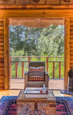 a living room with a couch and a large window at Tulbagh Mountain Cabin in Wolseley