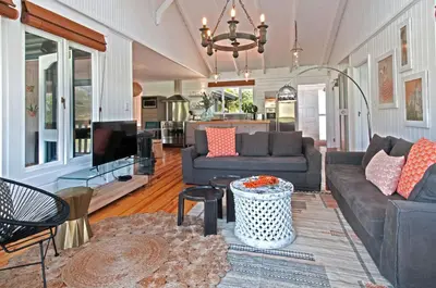 a living room with two couches and a tv at Moon River House in Pringle Bay