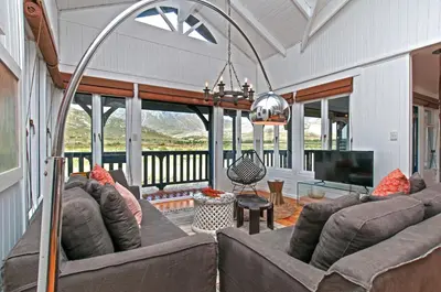 a living room with a couch and a television at Moon River House in Pringle Bay