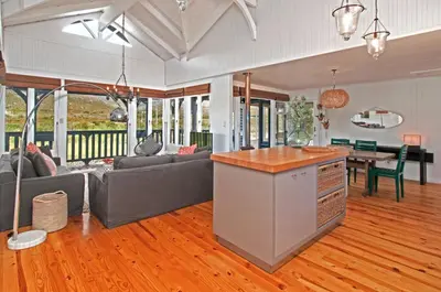 a kitchen and living room with a couch and a table at Moon River House in Pringle Bay