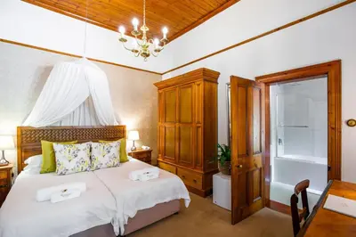 a bedroom with a bed with two towels on it at Roosenwijn Guesthouse in Stellenbosch