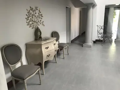 a room with chairs and a dresser with a vase on it at At Home in Mostertsdrift in Stellenbosch