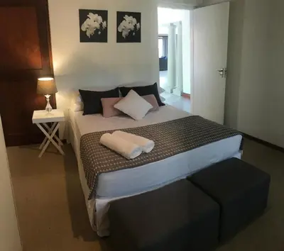 a bedroom with a large bed with two pillows on it at At Home in Mostertsdrift in Stellenbosch