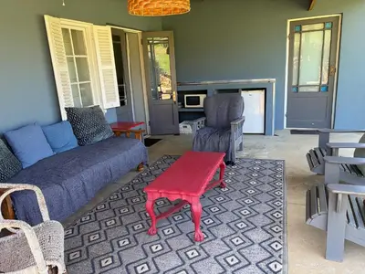 a living room with a couch and a table and chairs at Shabach Farm in Hartebeest Rivier