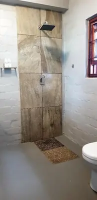 a bathroom with a shower with a toilet at Hemel en Aarde Village Accommodation in Hermanus