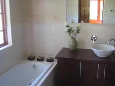 a bathroom with a bath tub and a sink at Acara Guesthouse & Cottages in Stellenbosch