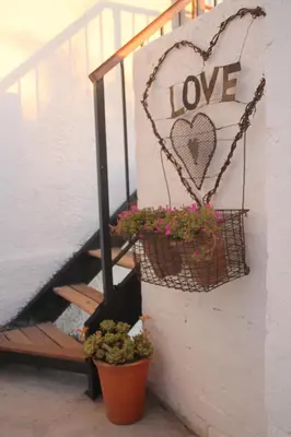a sign that says love with potted plants next to stairs at Acara Guesthouse & Cottages in Stellenbosch