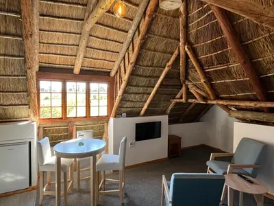 a room with a table and chairs and a tv at Acara Guesthouse & Cottages in Stellenbosch