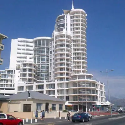 a large white building with cars parked in front of it at Hibernian Towers 1802 Self Catering Accommodation Strand Western Cape South Africa in Strand