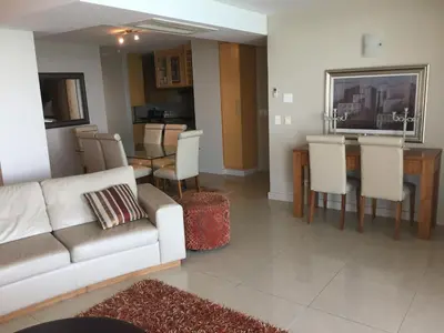 a living room with a couch and a table and chairs at Hibernian Towers 1802 Self Catering Accommodation Strand Western Cape South Africa in Strand