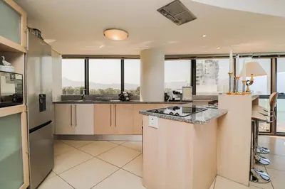 a large kitchen with a counter and some windows at Ocean View 505 Self Catering Accommodation Strand Western Cape South Africa in Strand