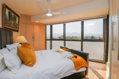 a bedroom with a bed with a large window at Ocean View 505 Self Catering Accommodation Strand Western Cape South Africa in Strand