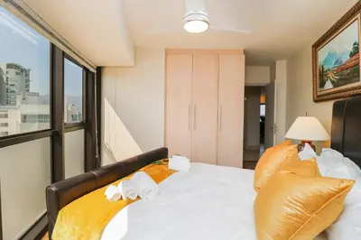 a bedroom with a large bed with orange pillows at Ocean View 505 Self Catering Accommodation Strand Western Cape South Africa in Strand