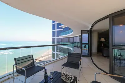 a balcony with two chairs and a view of the ocean at Ocean View 505 Self Catering Accommodation Strand Western Cape South Africa in Strand