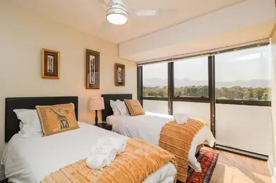 a bedroom with two beds and a large window at Ocean View 505 Self Catering Accommodation Strand Western Cape South Africa in Strand